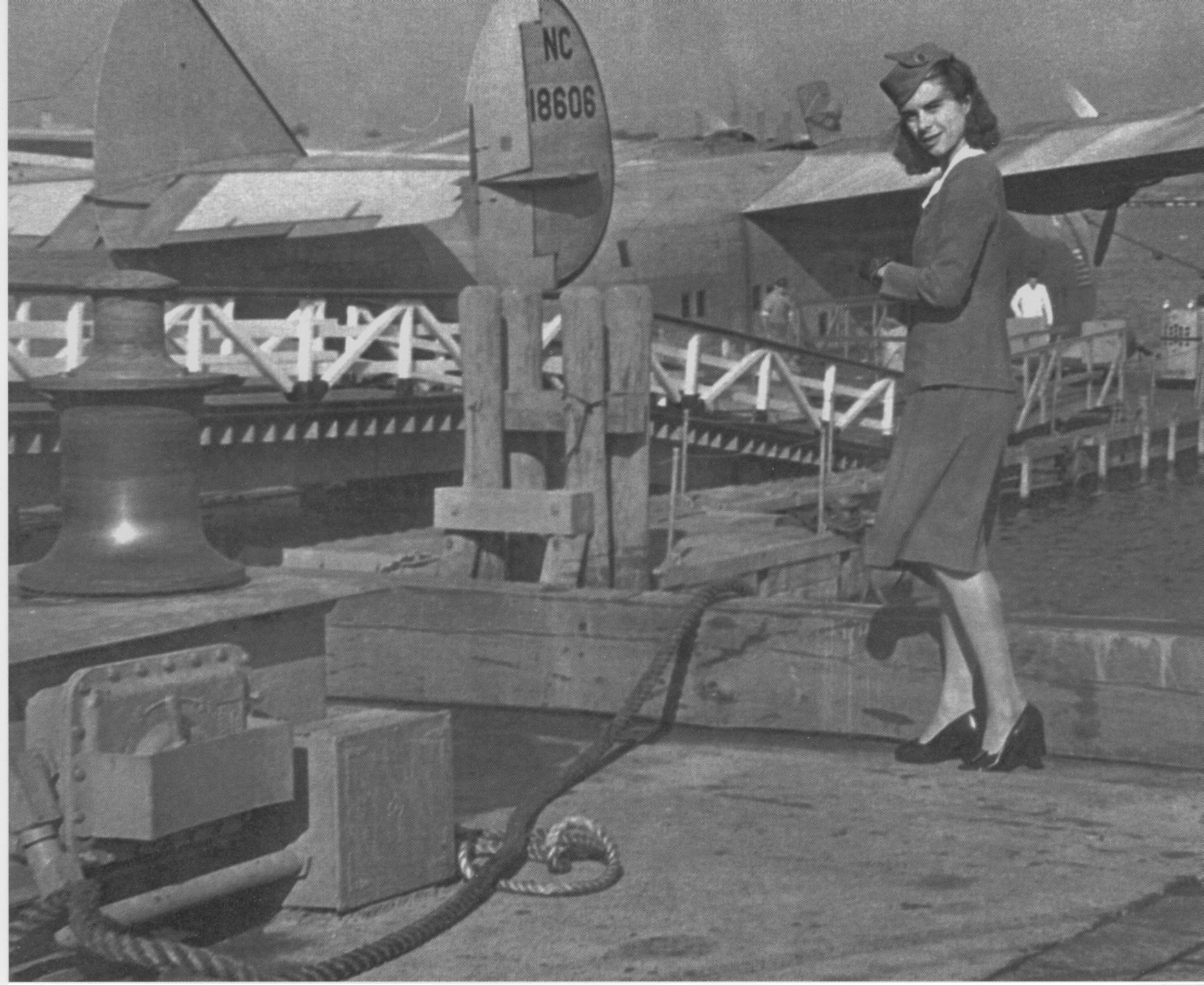 1945 Stewardess Lotta Westerhortsmann posing with Boeing 314 flying boat at the dock